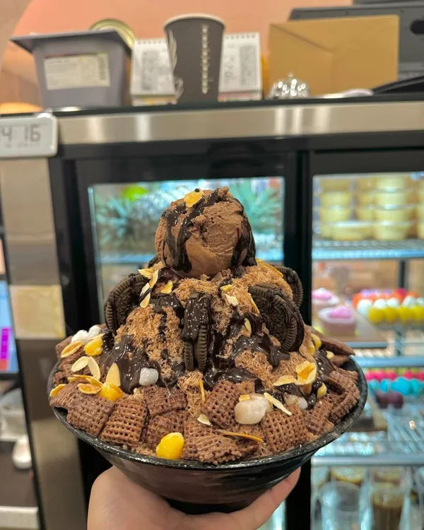 A chocolate bingsu held up by the cake cabinet